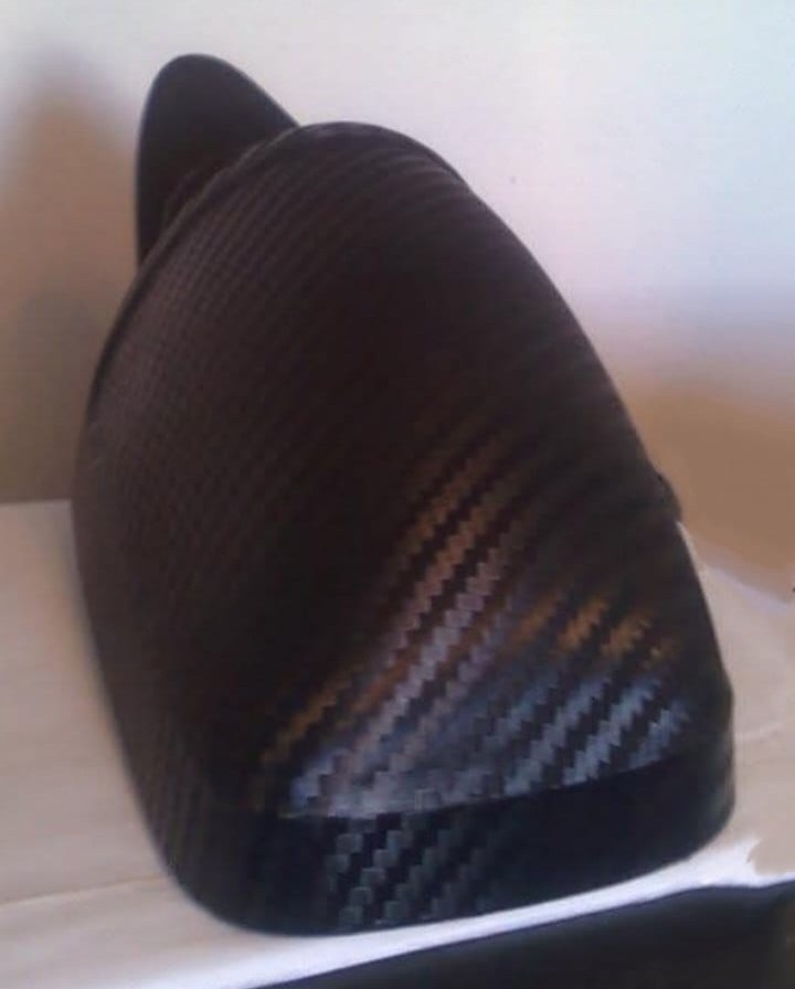 A wing mirror covered in a dark carbon-fiber-patterned finish.